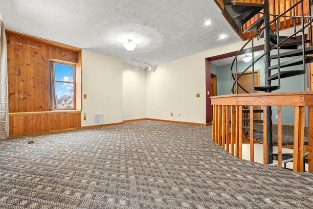 117 Franklin St, Marietta, OH 45750 - carpeted empty room featuring wood walls, a textured ceiling, recessed lighting, and stairs