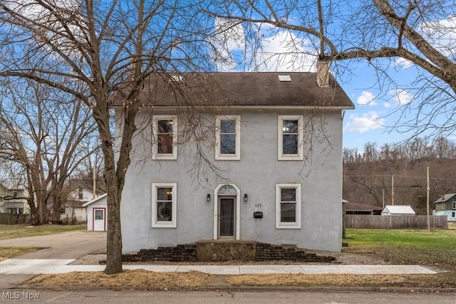 117 Franklin St, Marietta, OH 45750 - colonial-style house featuring a chimney, stucco siding, and concrete driveway