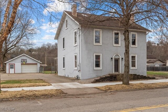 117 Franklin St, Marietta, OH 45750 - view of front of house featuring a chimney, an outdoor structure, stucco siding, a detached garage, and concrete driveway