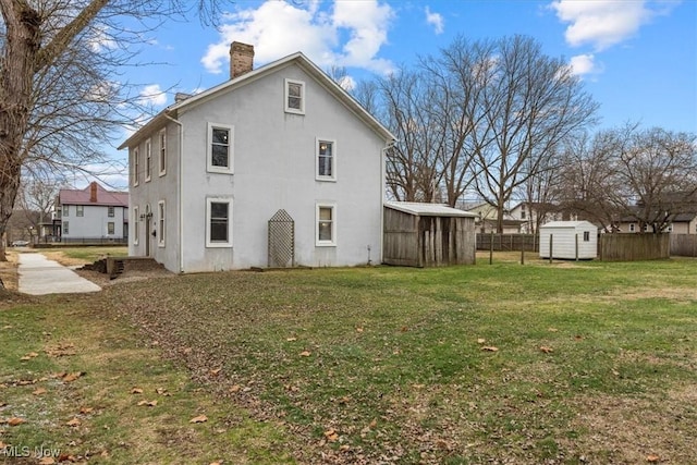 117 Franklin St, Marietta, OH 45750 - rear view of house with a storage shed, a chimney, and stucco siding