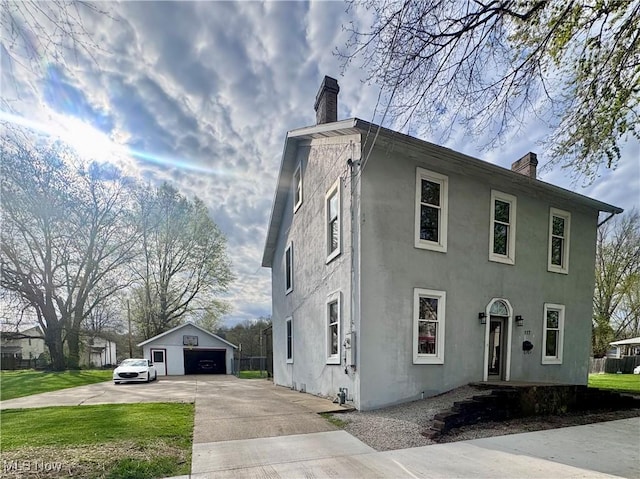 117 Franklin St, Marietta, OH 45750 - view of front of home featuring a chimney, a garage, an outdoor structure, and stucco siding