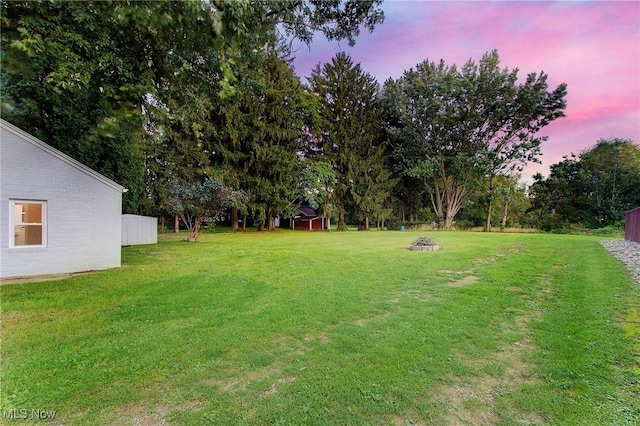 yard at dusk featuring an outdoor fire pit