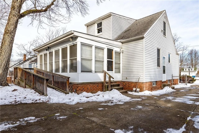 snow covered property with a sunroom