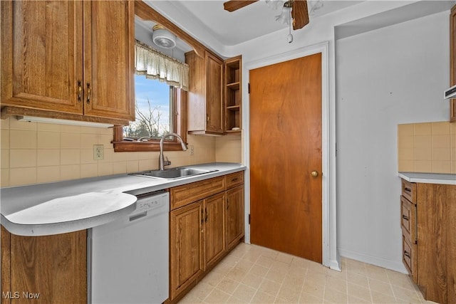 kitchen featuring ceiling fan, dishwasher, sink, and backsplash