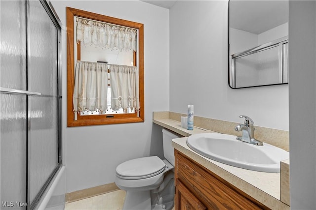 full bathroom featuring enclosed tub / shower combo, vanity, and toilet