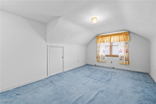 bonus room with vaulted ceiling and carpet flooring