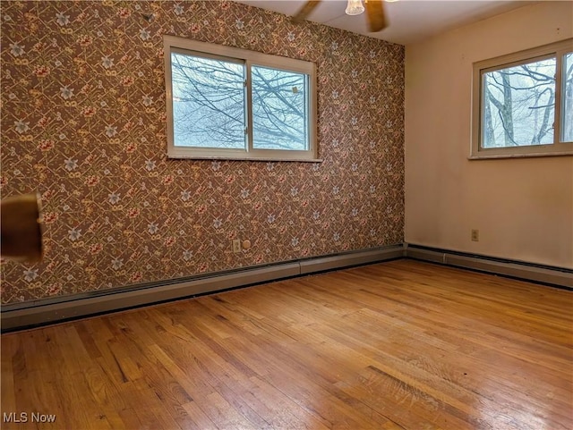 empty room featuring hardwood / wood-style floors, plenty of natural light, and ceiling fan