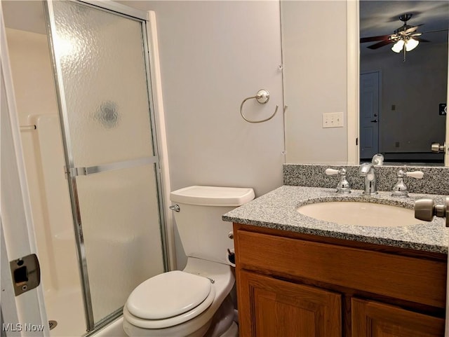 bathroom with ceiling fan, vanity, toilet, and a shower with shower door