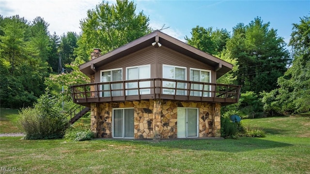 rear view of property featuring a deck and a lawn