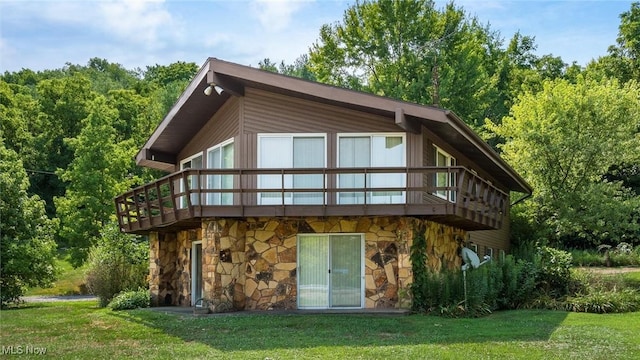 back of house featuring a wooden deck and a lawn