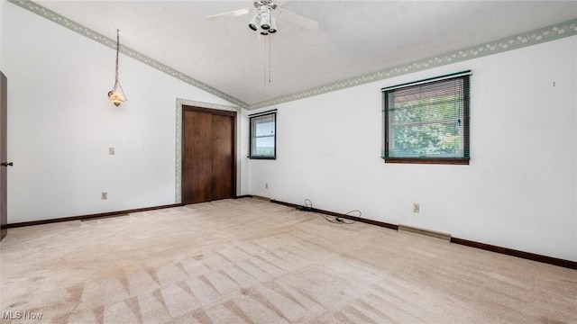 carpeted empty room with lofted ceiling and ceiling fan