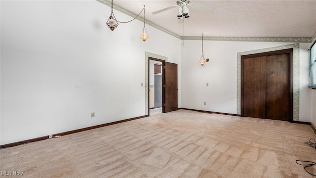 carpeted empty room featuring a high ceiling and ceiling fan