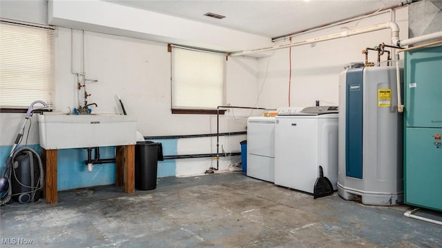 basement featuring water heater, sink, and washer and dryer