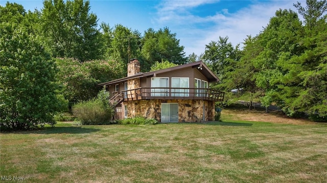 back of property featuring a wooden deck and a lawn