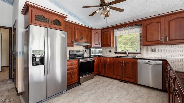 kitchen with lofted ceiling, sink, decorative backsplash, stainless steel appliances, and a textured ceiling