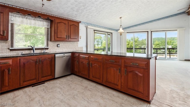 kitchen featuring pendant lighting, sink, vaulted ceiling, stainless steel dishwasher, and kitchen peninsula