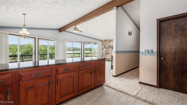 kitchen featuring ceiling fan, lofted ceiling with beams, a textured ceiling, decorative light fixtures, and light colored carpet