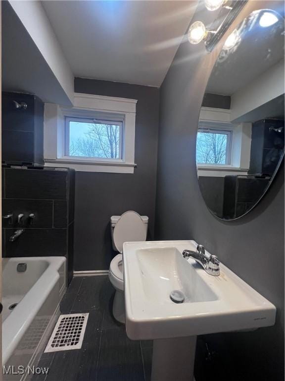 bathroom featuring toilet, tile patterned flooring, and sink