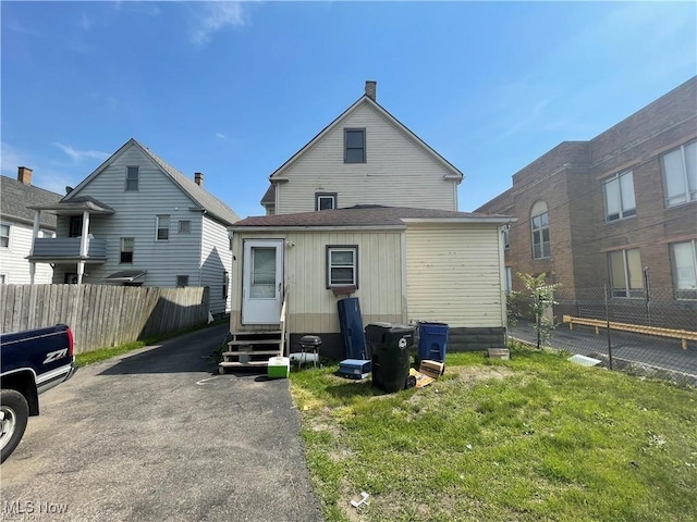 rear view of house featuring a yard