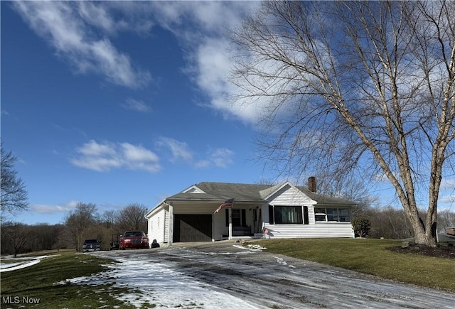 ranch-style house with a garage and a front lawn