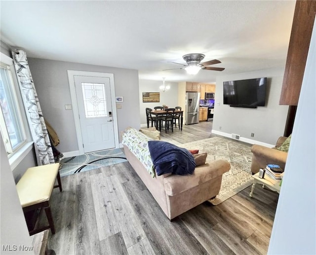 living room featuring wood-type flooring and ceiling fan