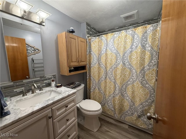 bathroom featuring toilet, tasteful backsplash, a textured ceiling, vanity, and hardwood / wood-style flooring