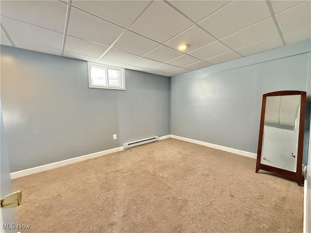 basement with carpet, a drop ceiling, and baseboard heating