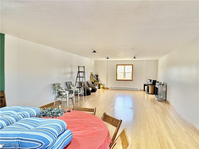 interior space with a baseboard heating unit and light hardwood / wood-style flooring