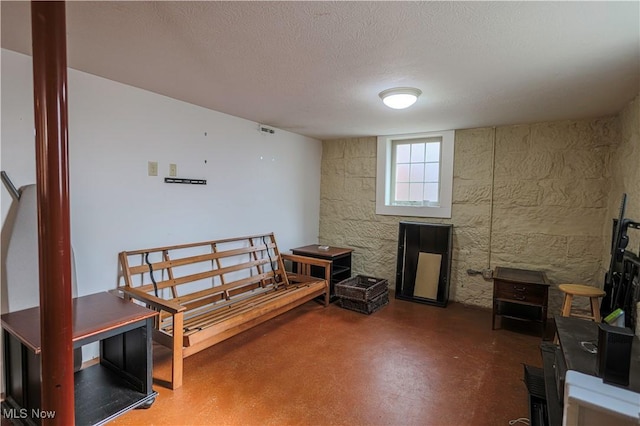 miscellaneous room with concrete floors and a textured ceiling