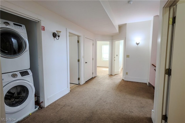 washroom featuring stacked washer / drying machine and light colored carpet