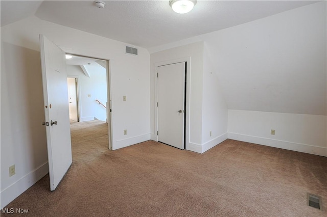 interior space with lofted ceiling and light carpet