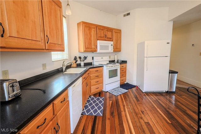 kitchen featuring pendant lighting, sink, dark wood-type flooring, and white appliances