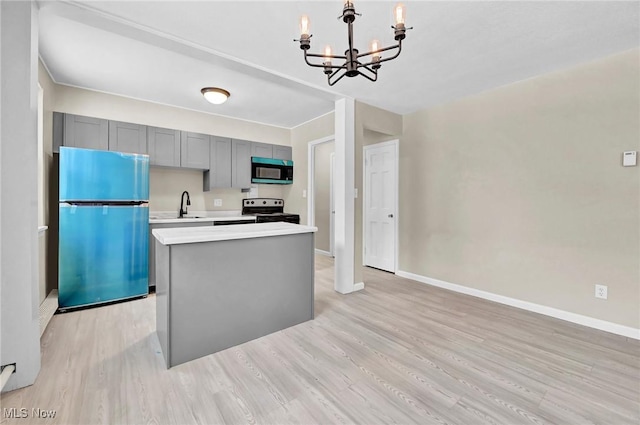 kitchen featuring stainless steel electric range, light hardwood / wood-style flooring, gray cabinets, hanging light fixtures, and fridge