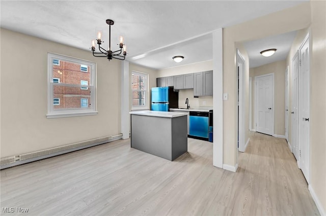 kitchen featuring light hardwood / wood-style flooring, a baseboard heating unit, hanging light fixtures, stainless steel appliances, and a kitchen island