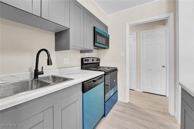 kitchen featuring gray cabinets, electric range oven, sink, stainless steel dishwasher, and light hardwood / wood-style flooring