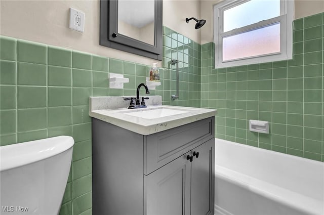 full bathroom featuring tiled shower / bath combo, vanity, tile walls, and toilet