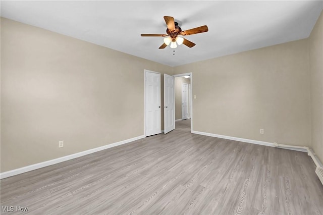 spare room with ceiling fan and light wood-type flooring