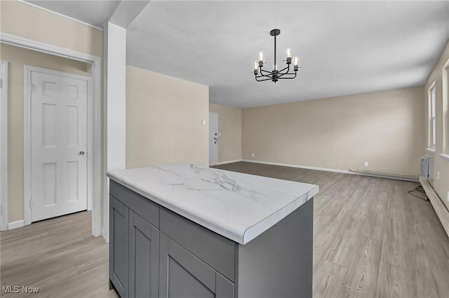 kitchen with a notable chandelier, decorative light fixtures, light hardwood / wood-style floors, and gray cabinetry