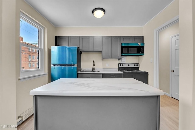 kitchen featuring sink, refrigerator, gray cabinetry, range with electric cooktop, and light hardwood / wood-style floors