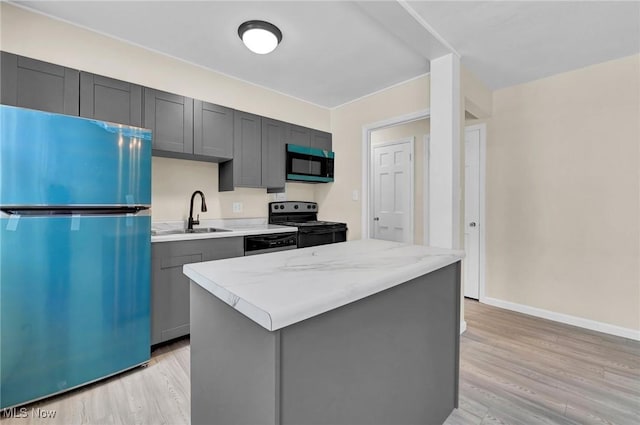 kitchen with gray cabinets, a kitchen island, sink, fridge, and black electric range