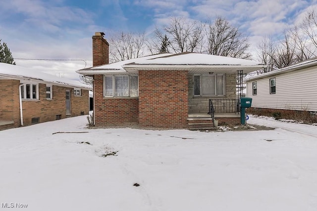 view of snow covered back of property