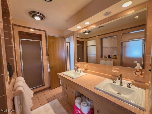 bathroom with vanity, tile patterned floors, a shower with door, and decorative backsplash