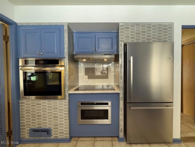 kitchen featuring backsplash, light tile patterned floors, stainless steel appliances, and blue cabinetry