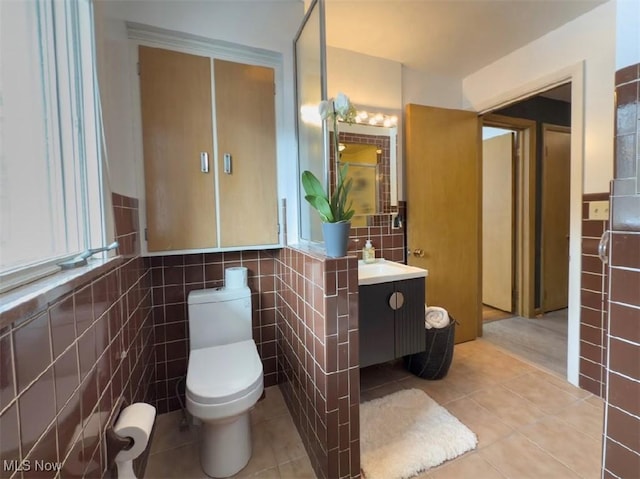 bathroom featuring tile walls, vanity, tile patterned floors, and toilet