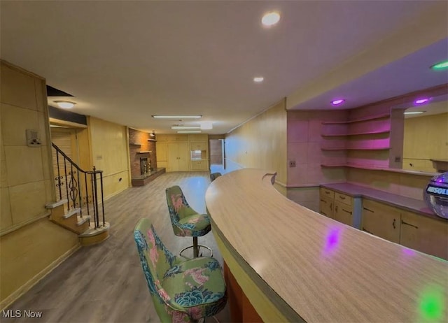 bar featuring light hardwood / wood-style floors and light brown cabinets