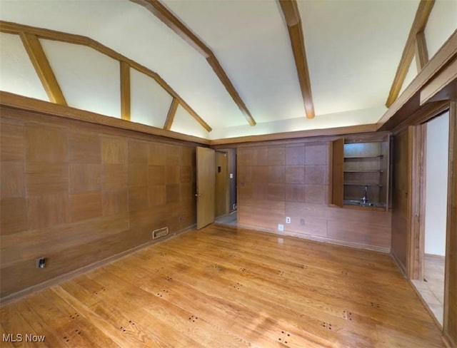 interior space featuring vaulted ceiling with beams and light wood-type flooring