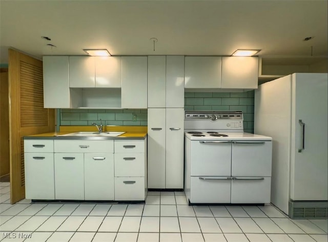 kitchen with light tile patterned floors, sink, double oven range, tasteful backsplash, and white cabinets