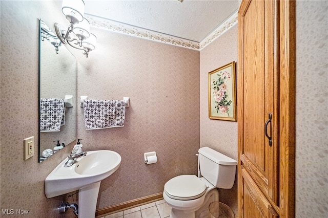 bathroom with a textured ceiling, tile patterned floors, and toilet