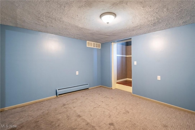 empty room featuring a baseboard radiator, carpet flooring, and a textured ceiling