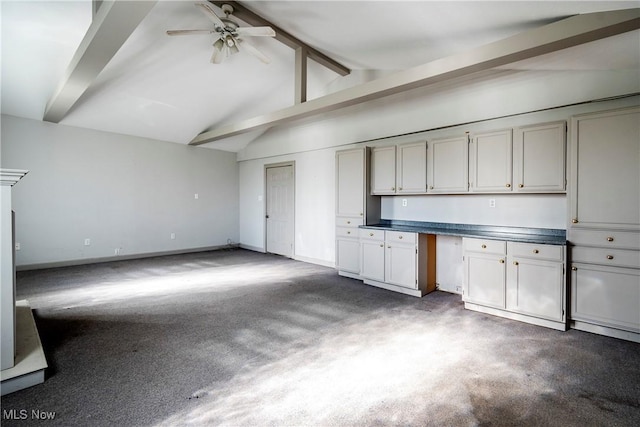 kitchen with lofted ceiling with beams, built in desk, and ceiling fan